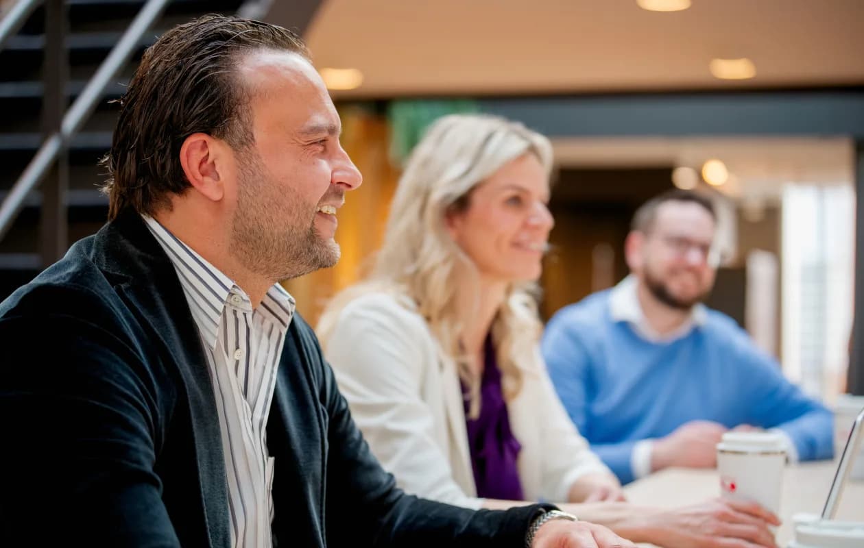 Drie personen in gesprek op kantoor