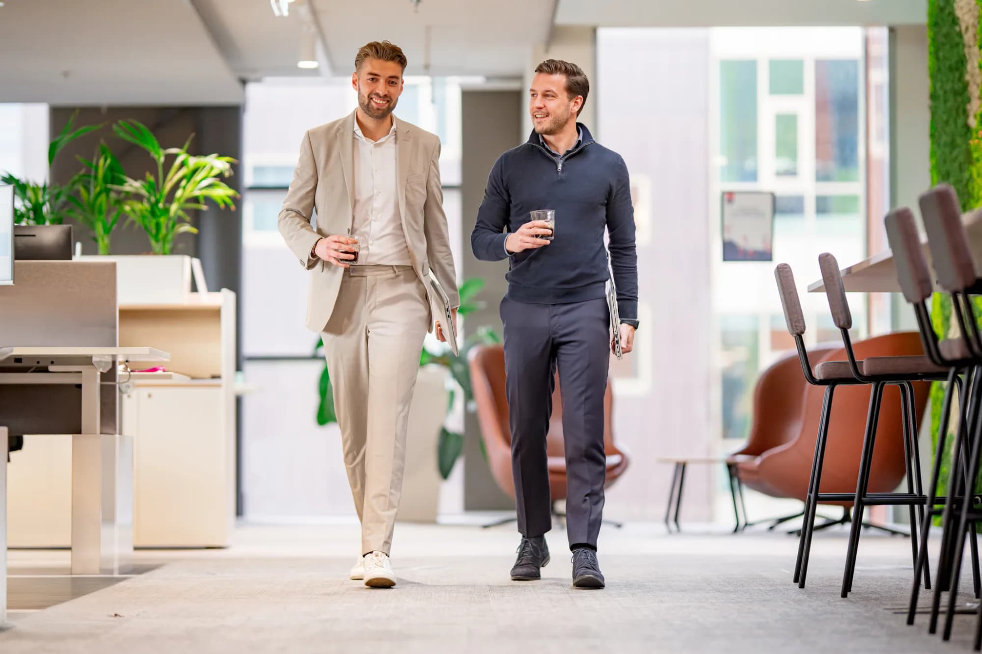 Twee collega's lopend door kantoor, in meeting over RPO