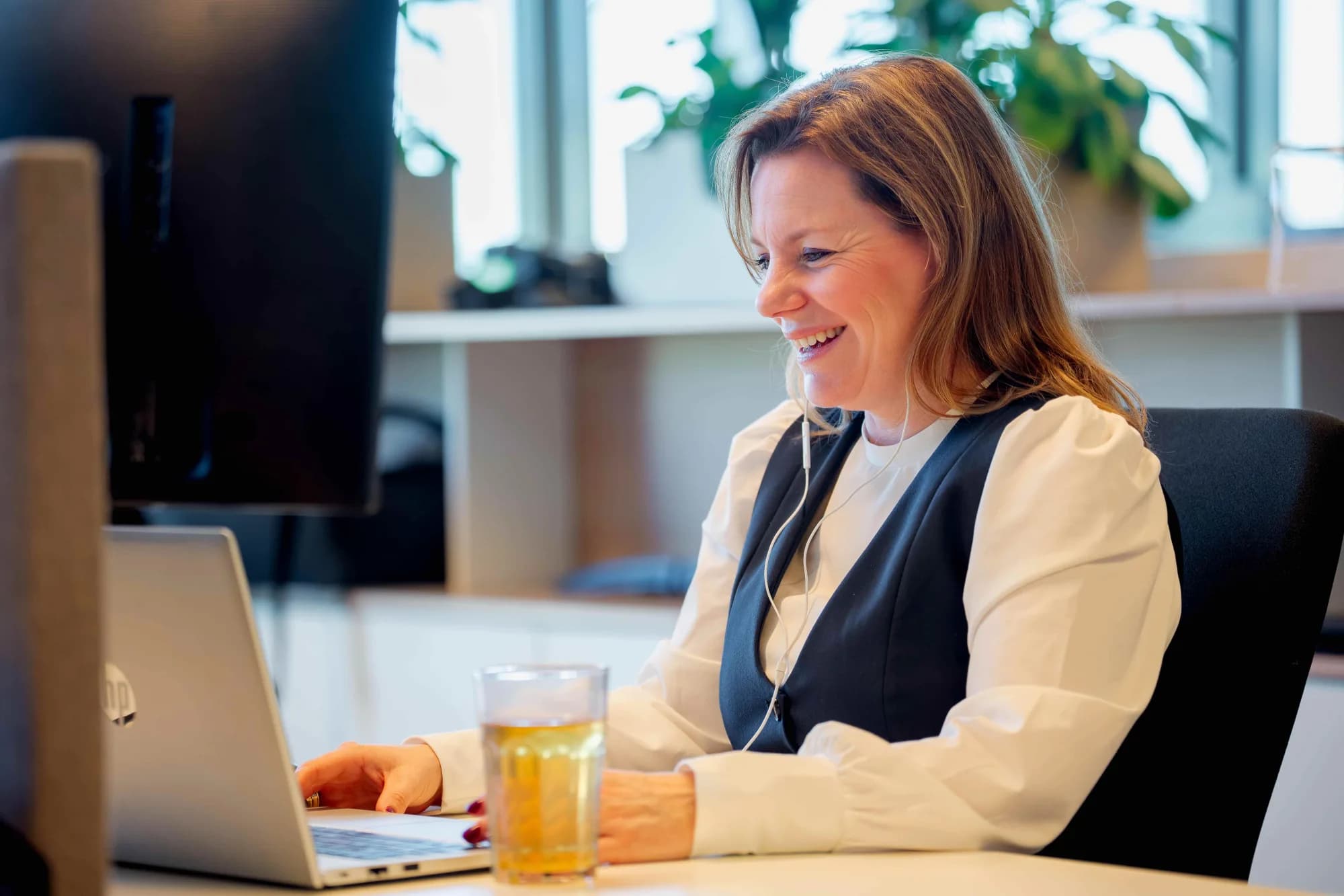 Woman lookt at laptop / selected as ICT partner for Inland Revenue, Surcharges and Customs