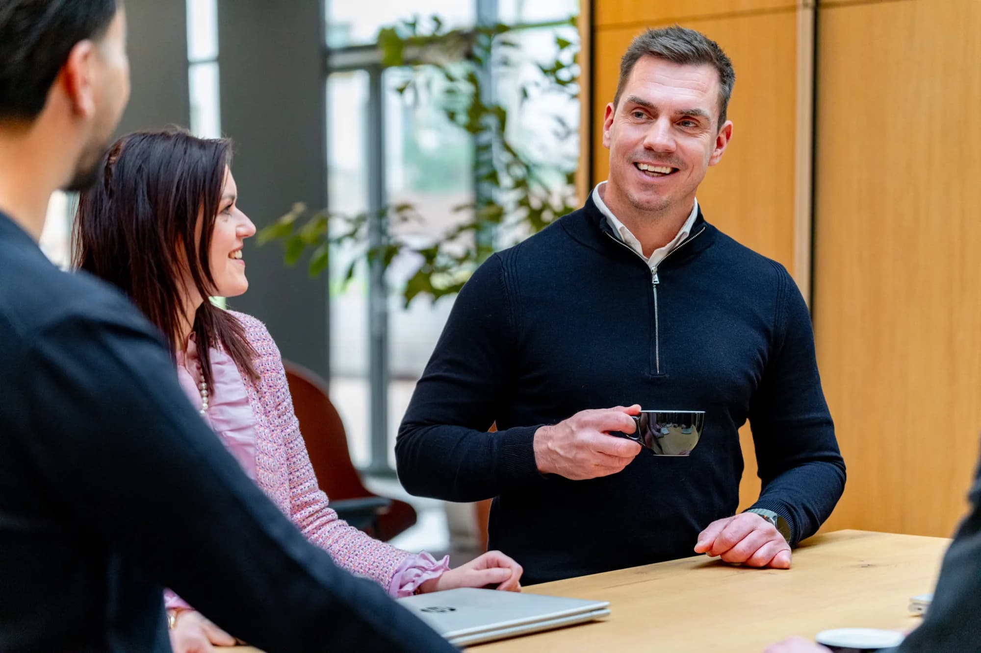 3 collega's overleggen met koffie en laptop